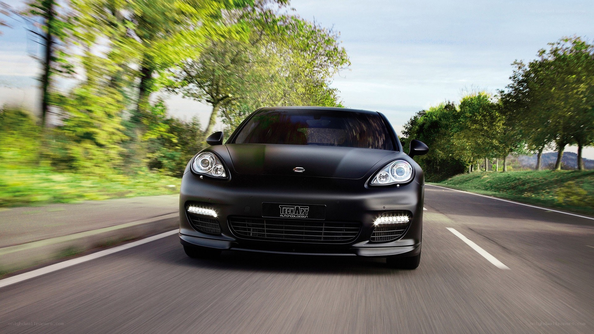 black car driving on road