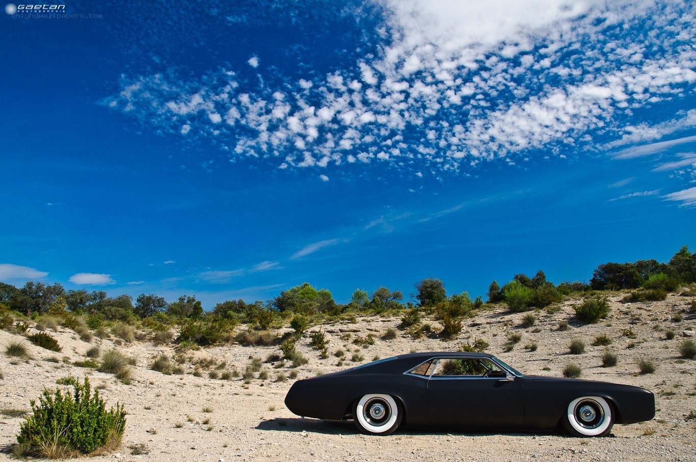 Black car in desert landscape