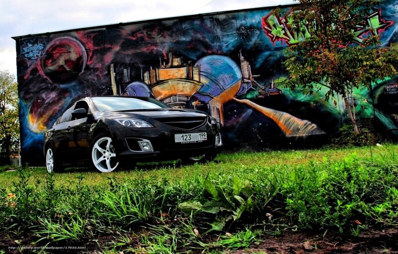 Black car in front of graffiti wall