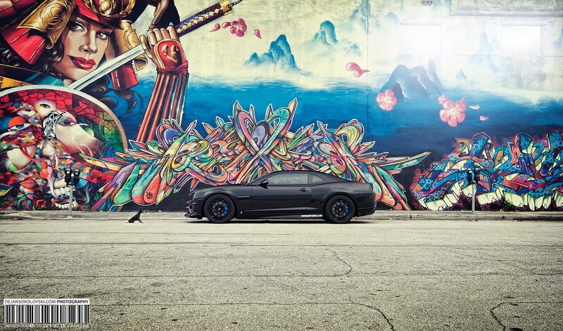 Black car in front of mural