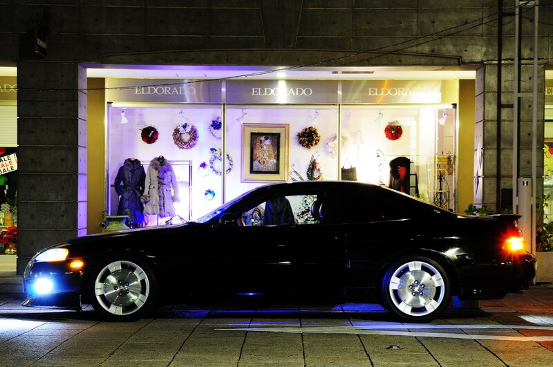 Black car in front of shop at night