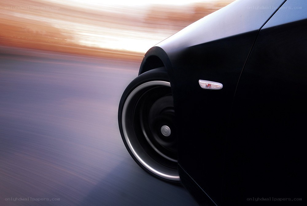 Black car in motion at sunset