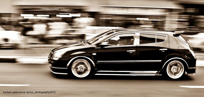 Black car in motion on city street
