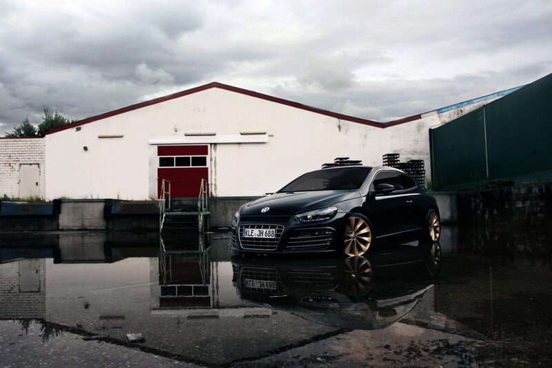 Black car in wet parking lot