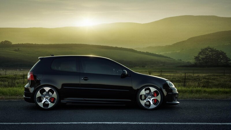 Black car on a road at sunset