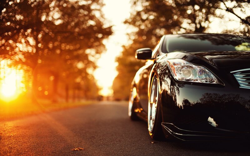 Black car on a road at sunset