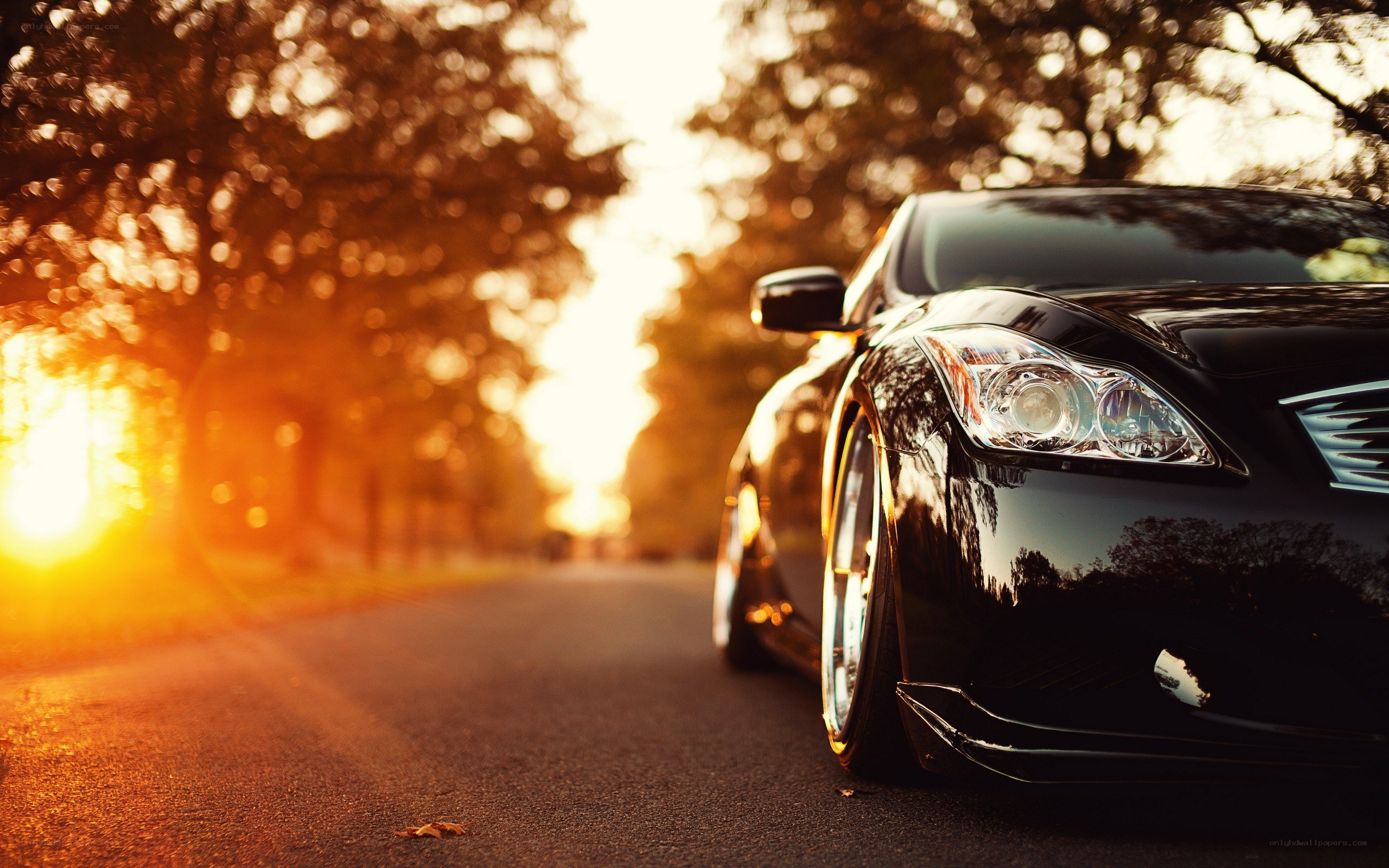 Black car on a road at sunset