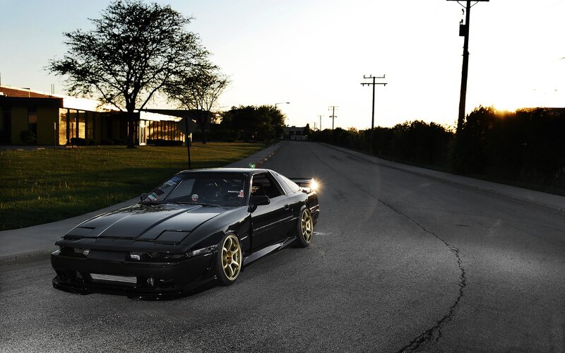 black car on a street at sunset