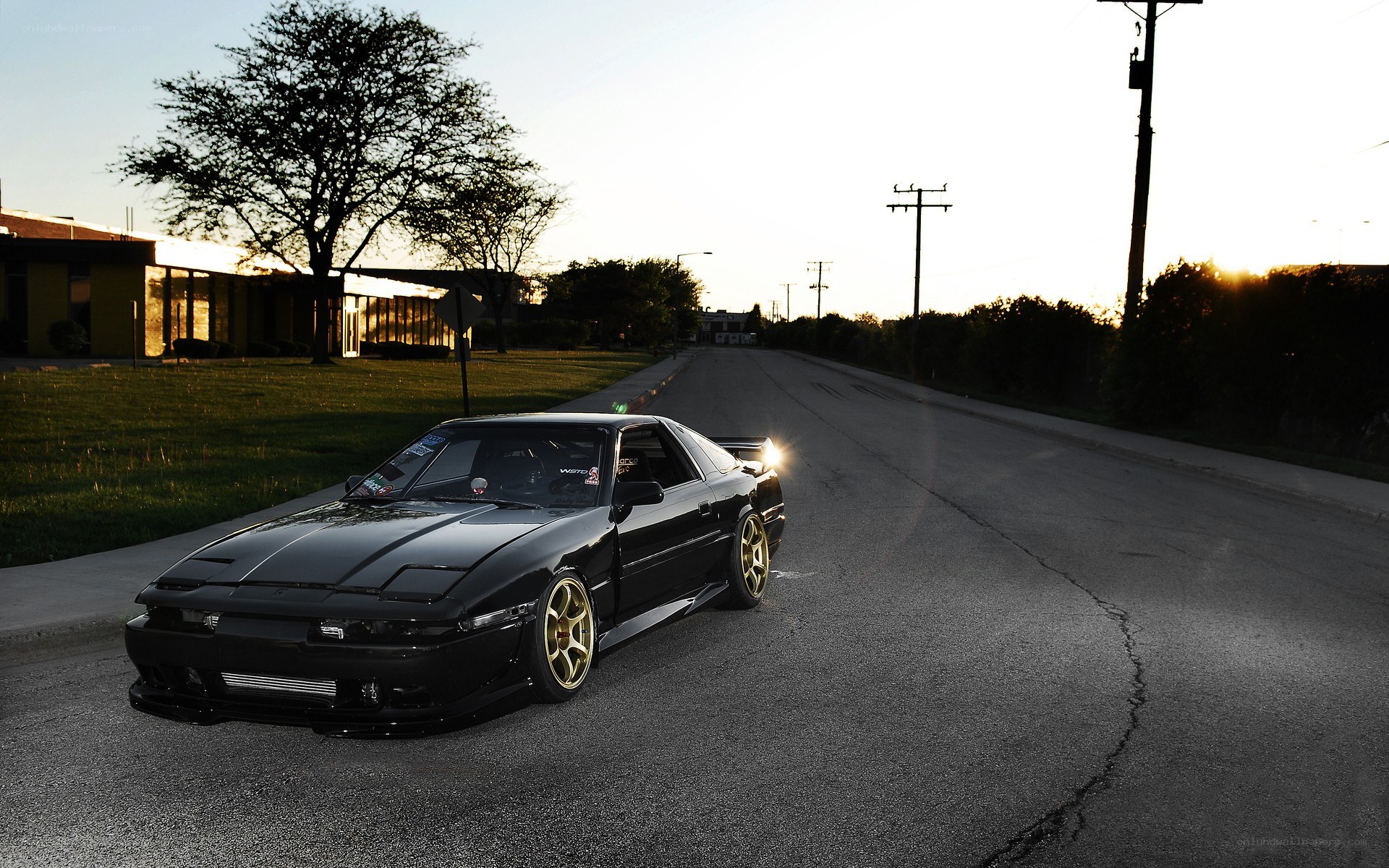 black car on a street at sunset