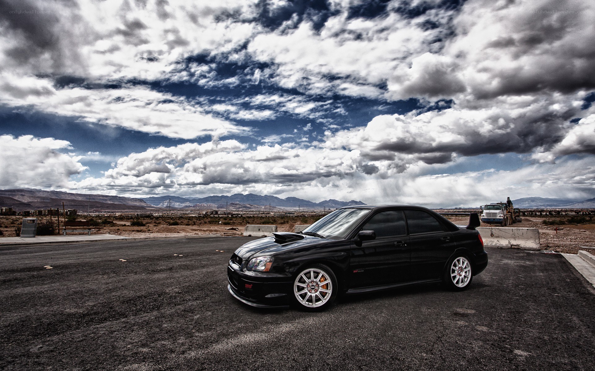 Black car on asphalt under cloudy sky