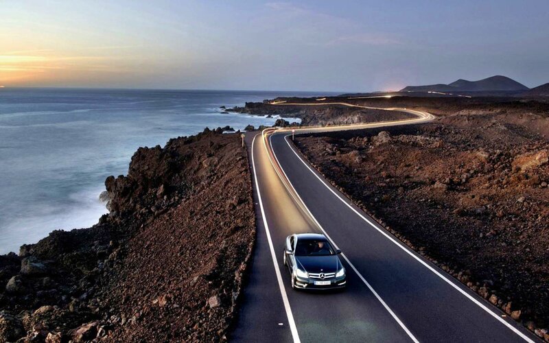 Black Car on Coastal Road — Blue