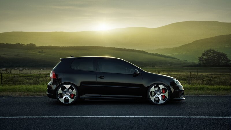 Black car on road at sunset