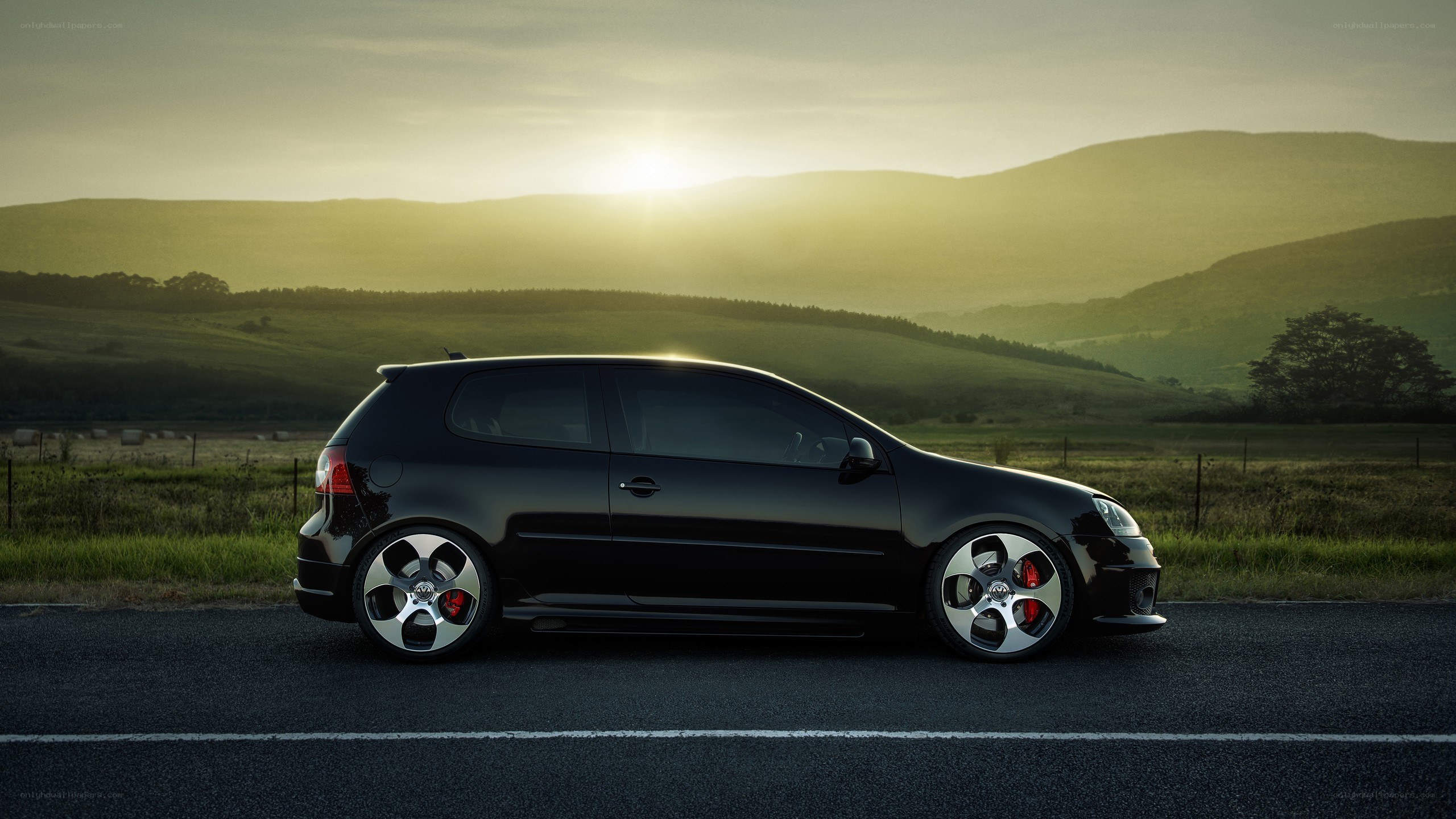 Black car on road at sunset