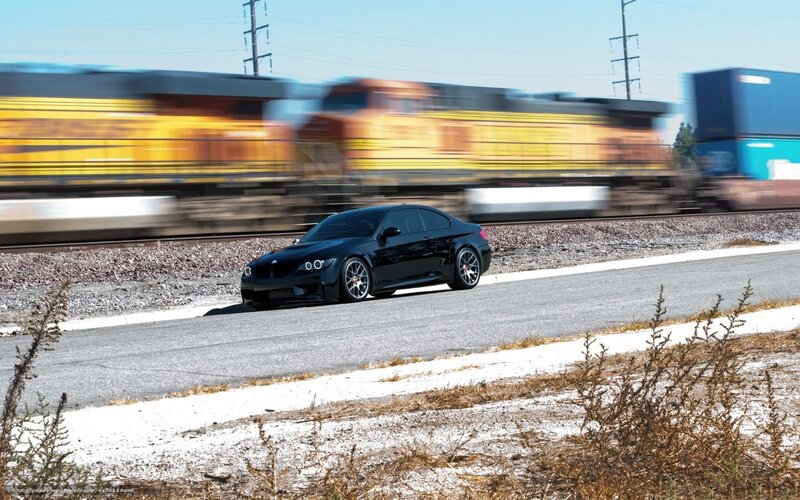 Black car on road near train