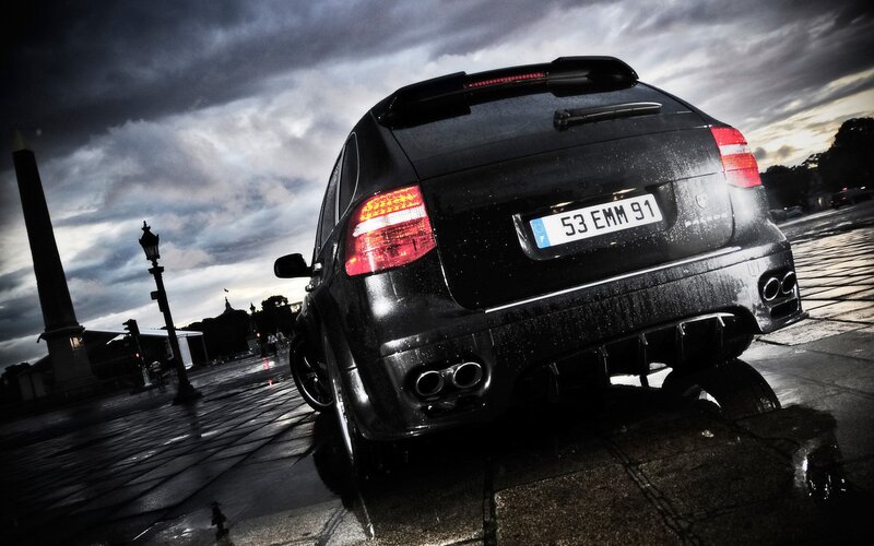 Black car on wet street at dusk