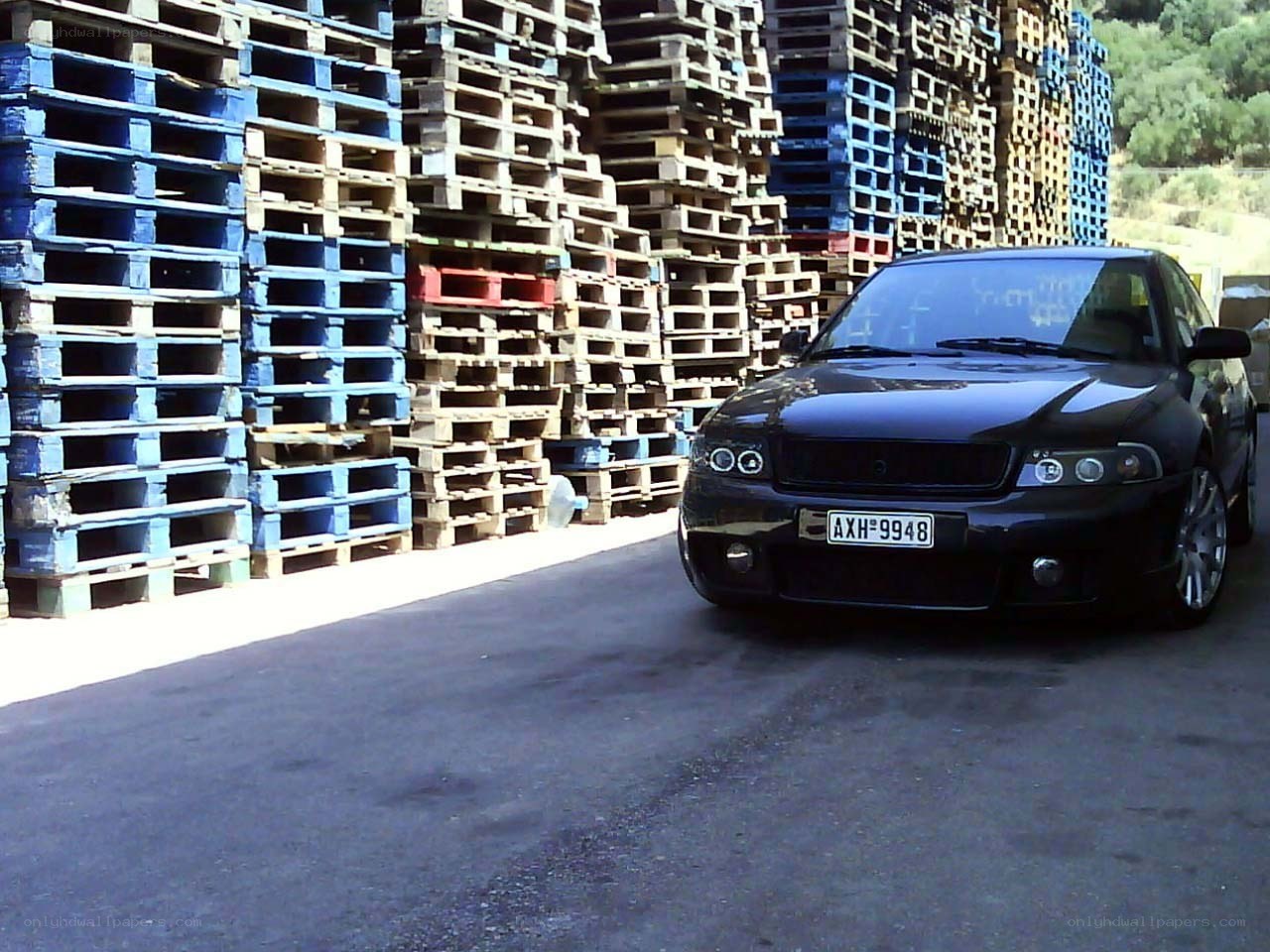Black car parked near pallets
