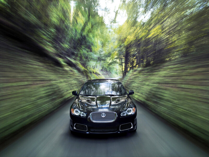 Black car speeding through forest
