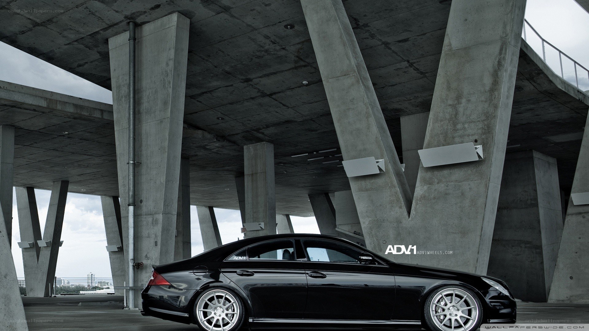 Black car under concrete bridge