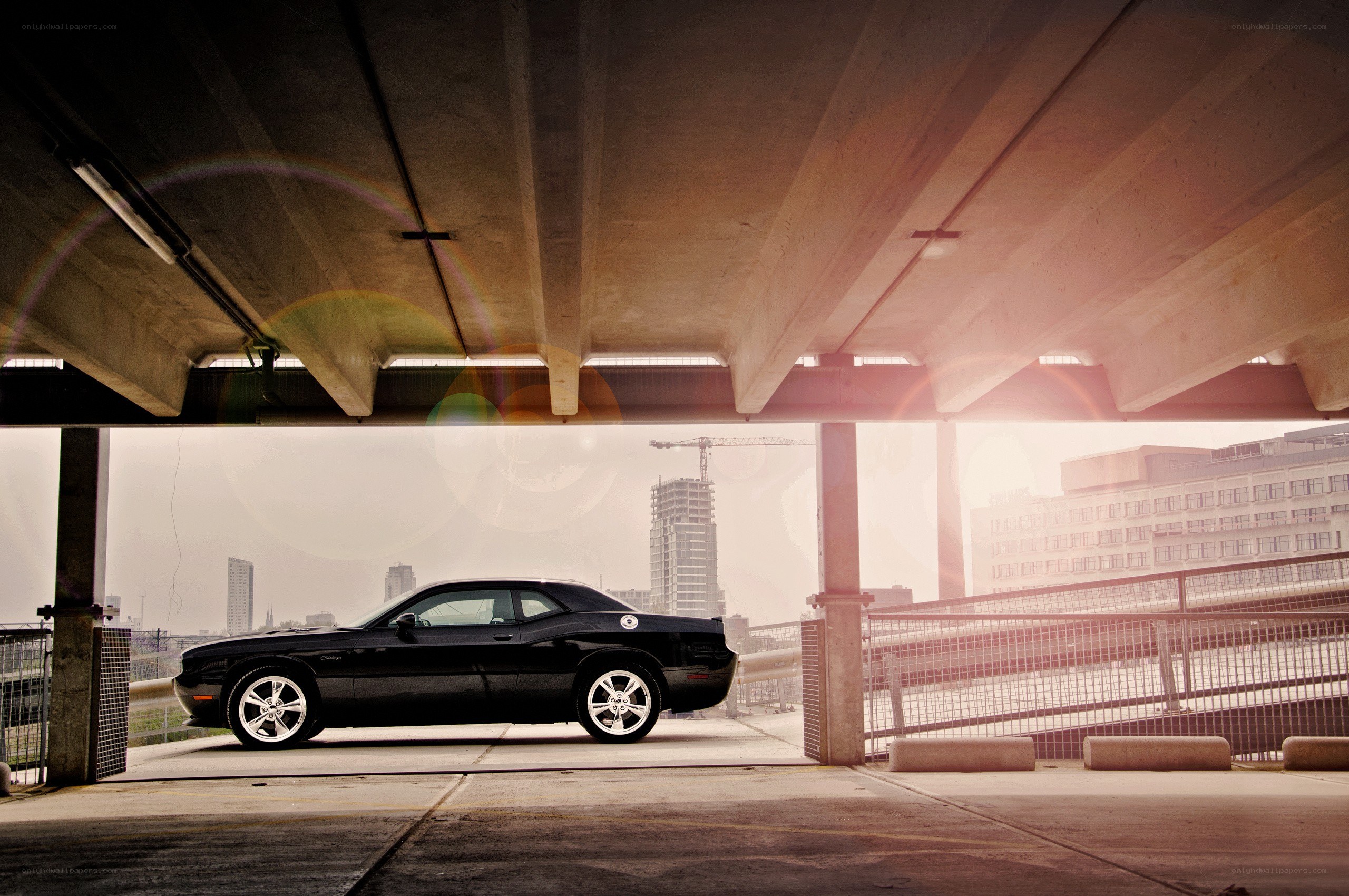Black car under concrete overpass