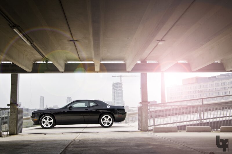 Black car under concrete overpass
