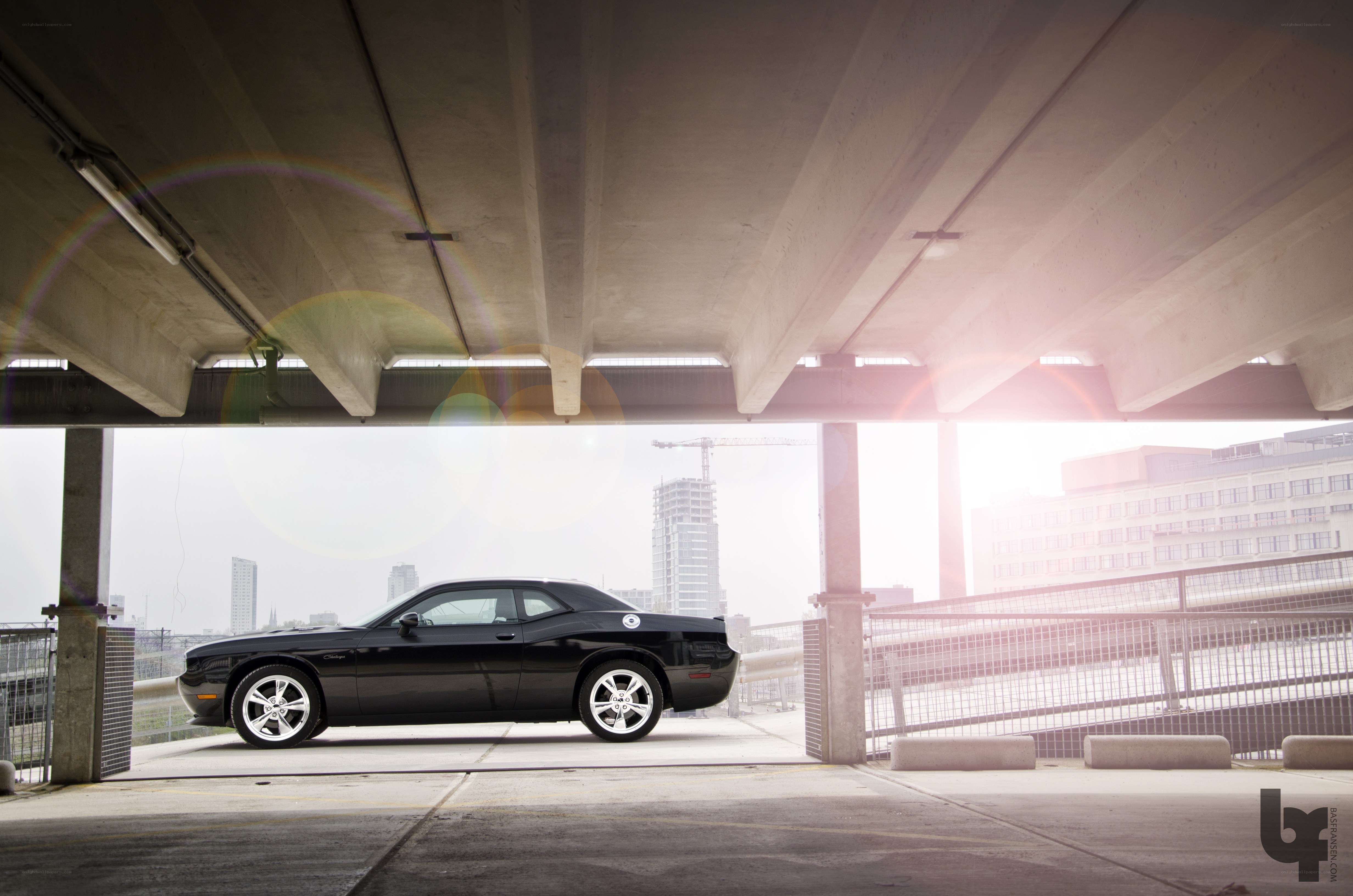 Black car under concrete overpass