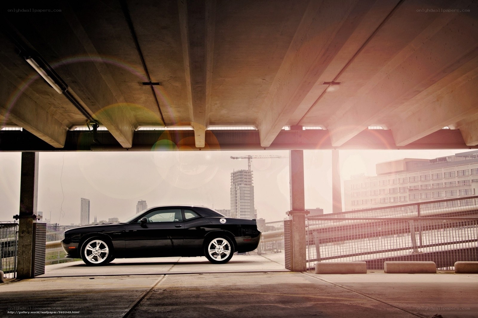 Black car under concrete overpass