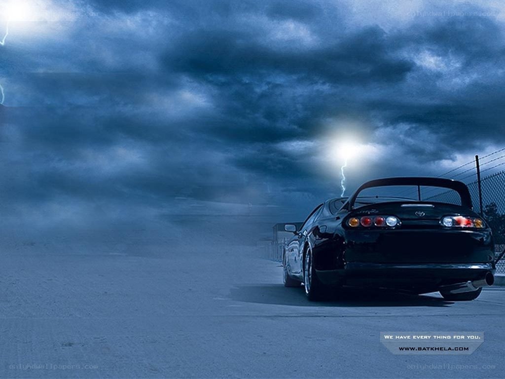 Black car under stormy sky