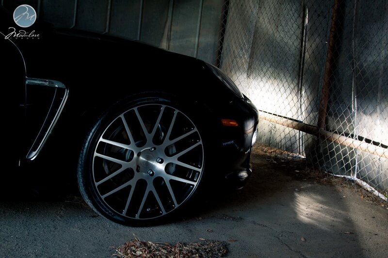Black Car Wheel — Dramatic, Photograph, Chain-link Fence