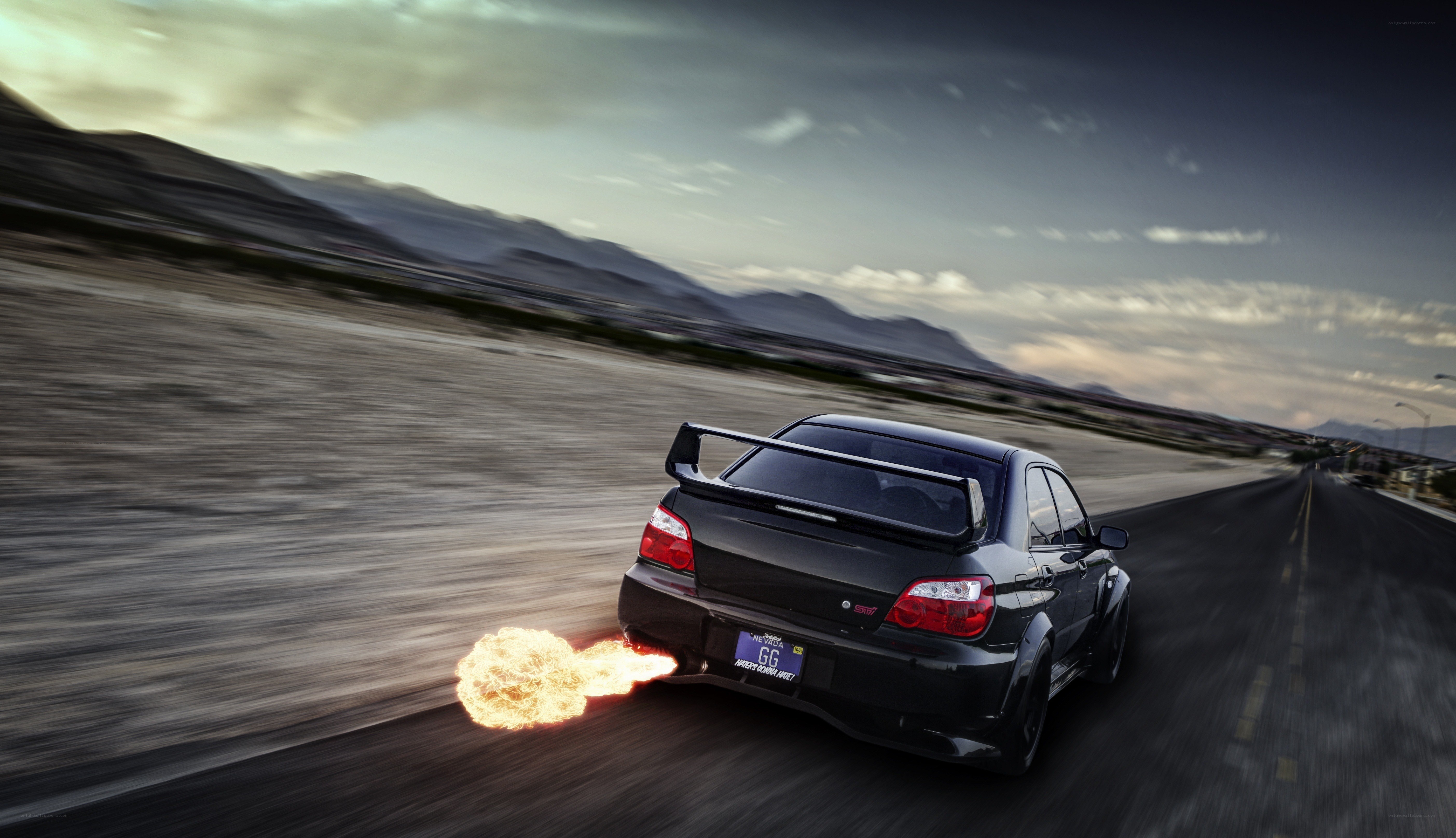 black car with flames on road