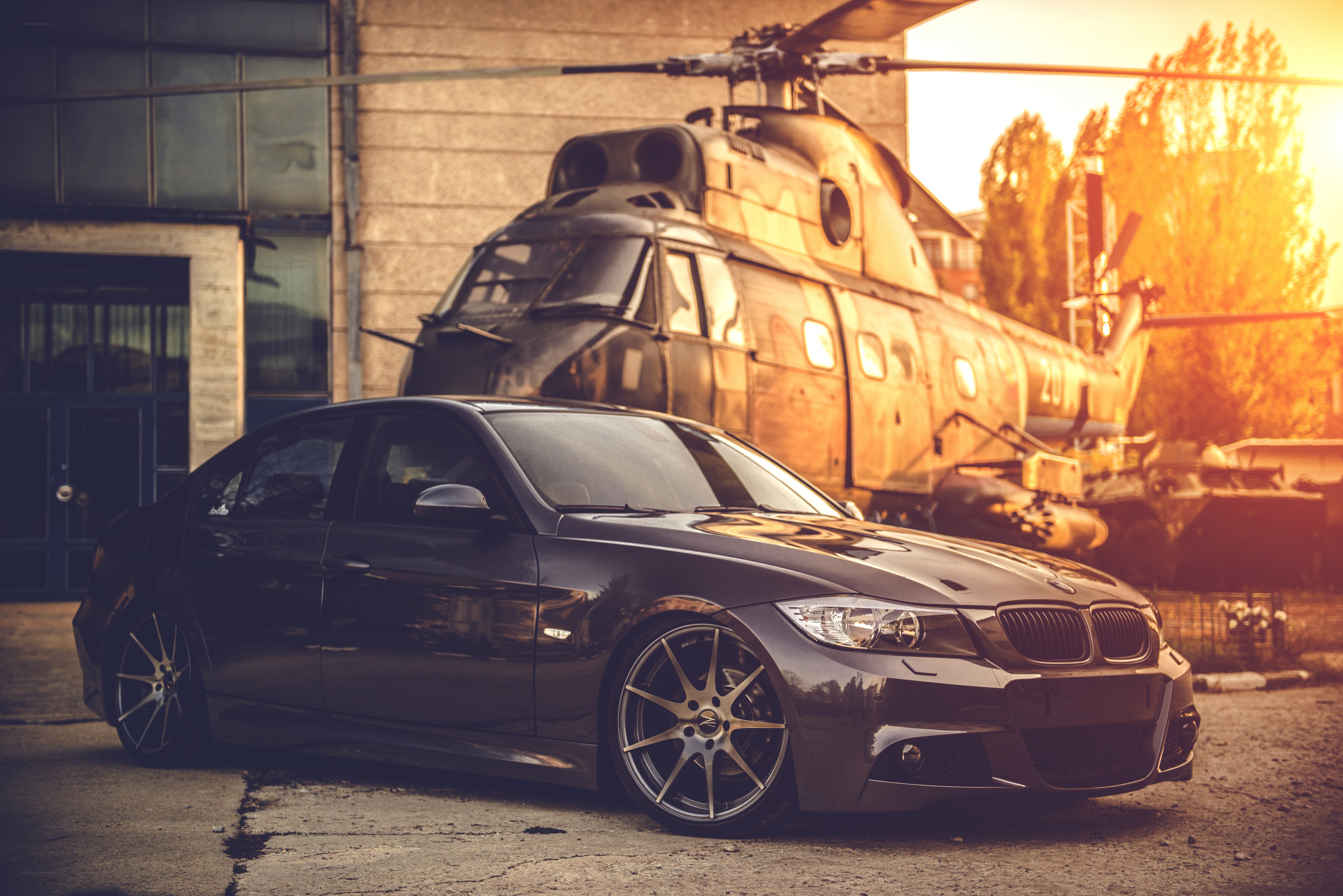 Black car with helicopter in background