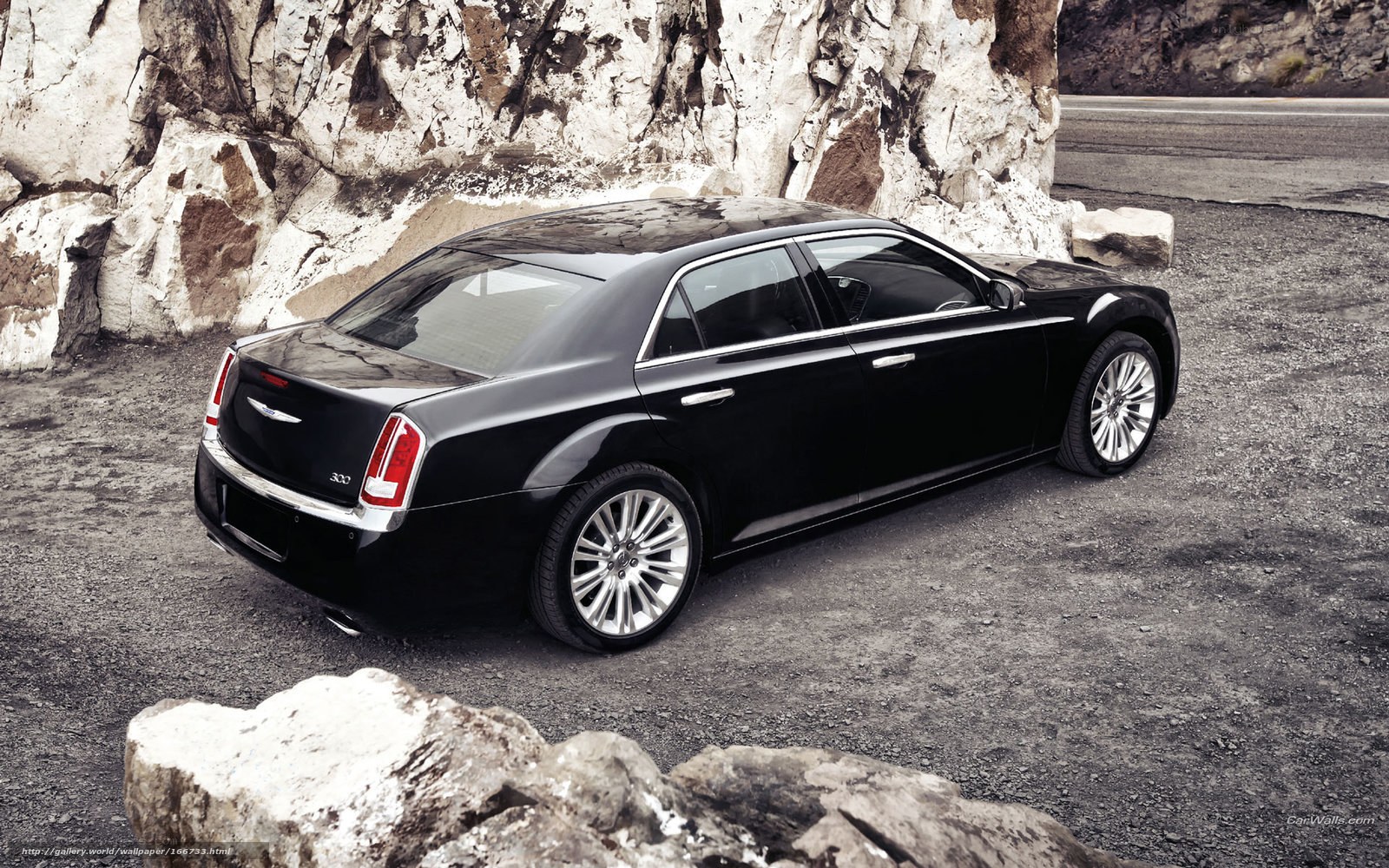 Black Chrysler 300 parked by rocks