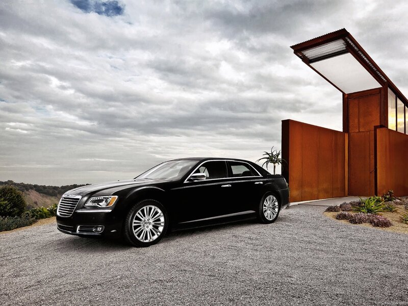 Black Chrysler 300 parked outside modern house