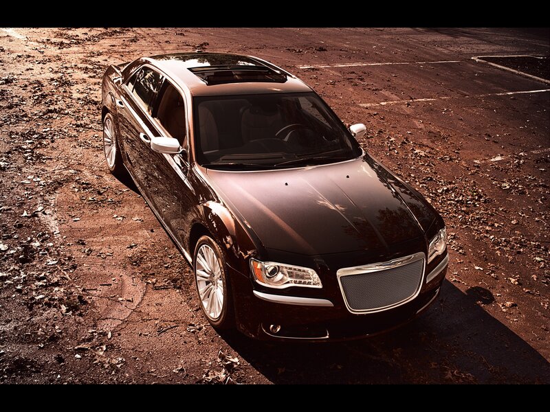 Black Chrysler sedan on dirt lot