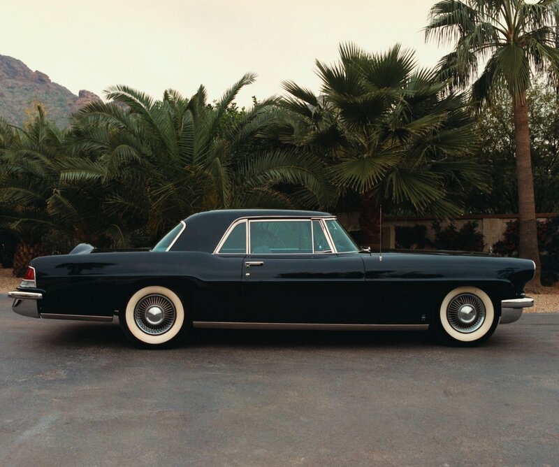 Black classic car in palm grove