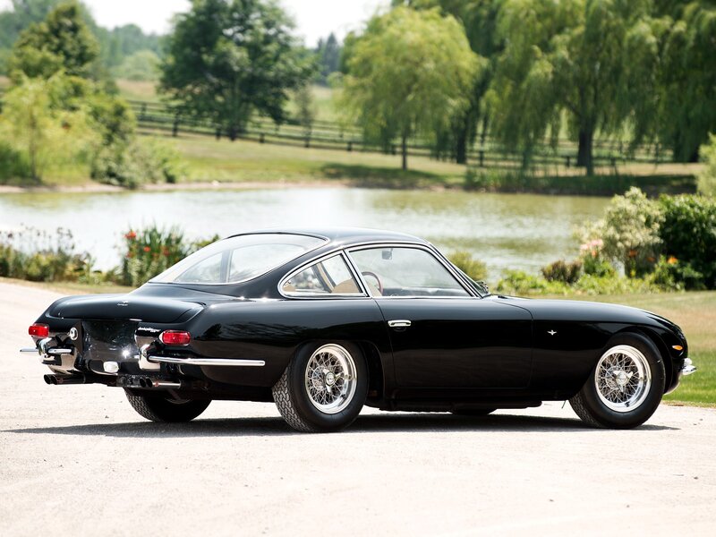 Black classic sports car by a pond
