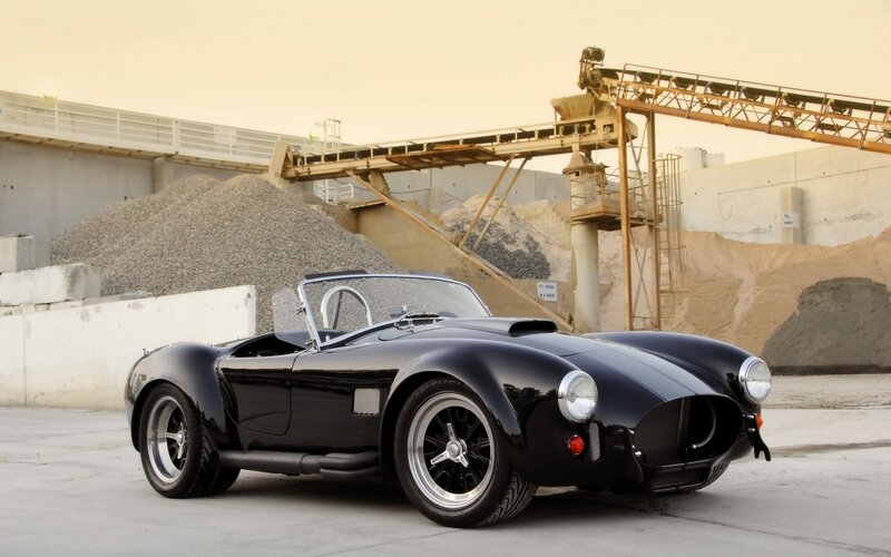 Black classic sports car in industrial setting
