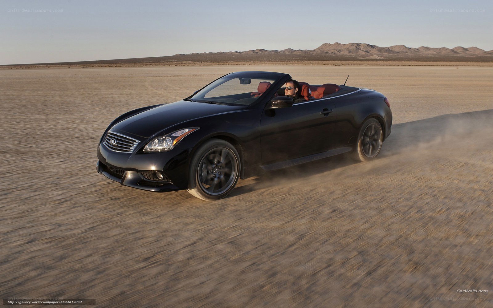 Black convertible driving in desert