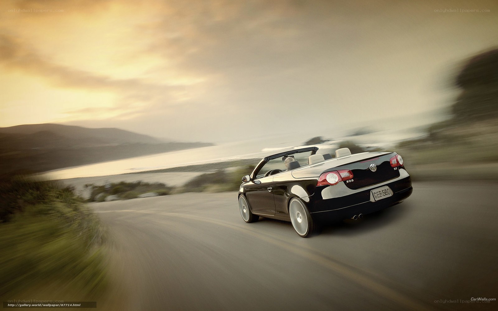 Black convertible driving on coastal road