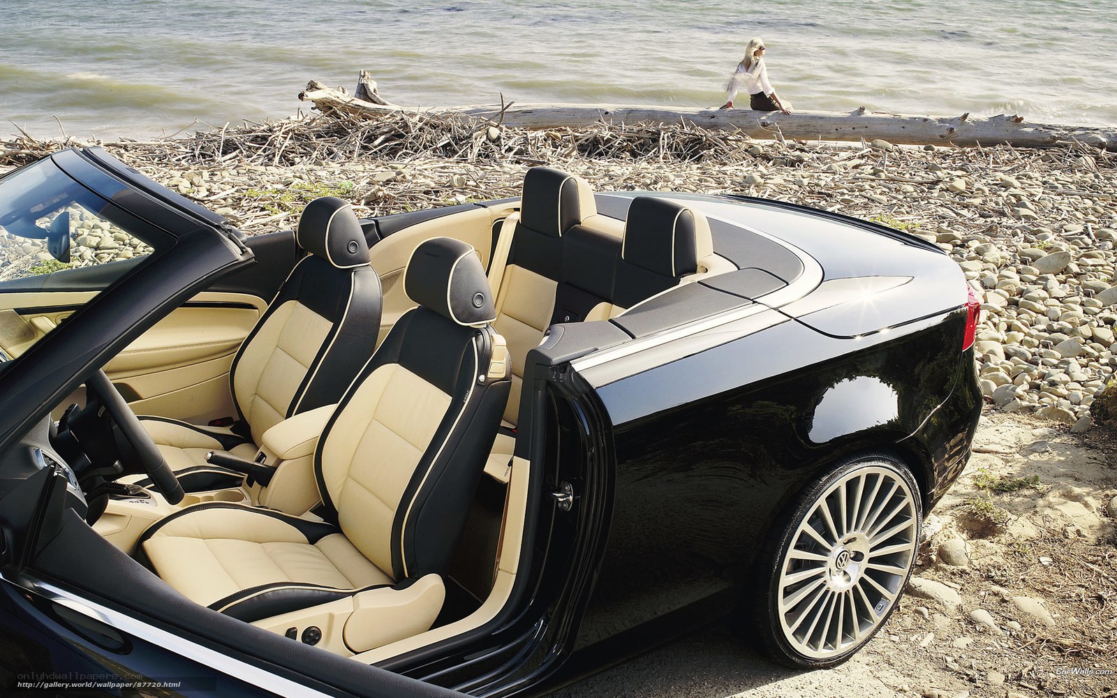 Black convertible on a pebble beach