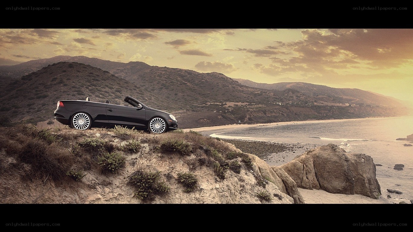 Black convertible on coastal cliff