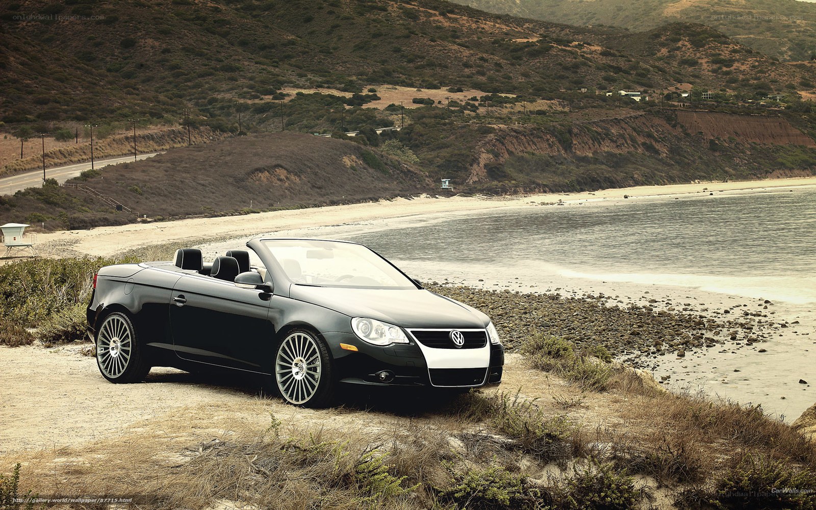 Black convertible on coastal cliff