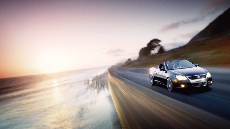 Black convertible on coastal road