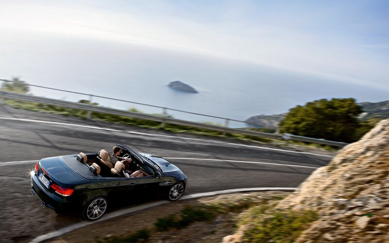 Black convertible on coastal road
