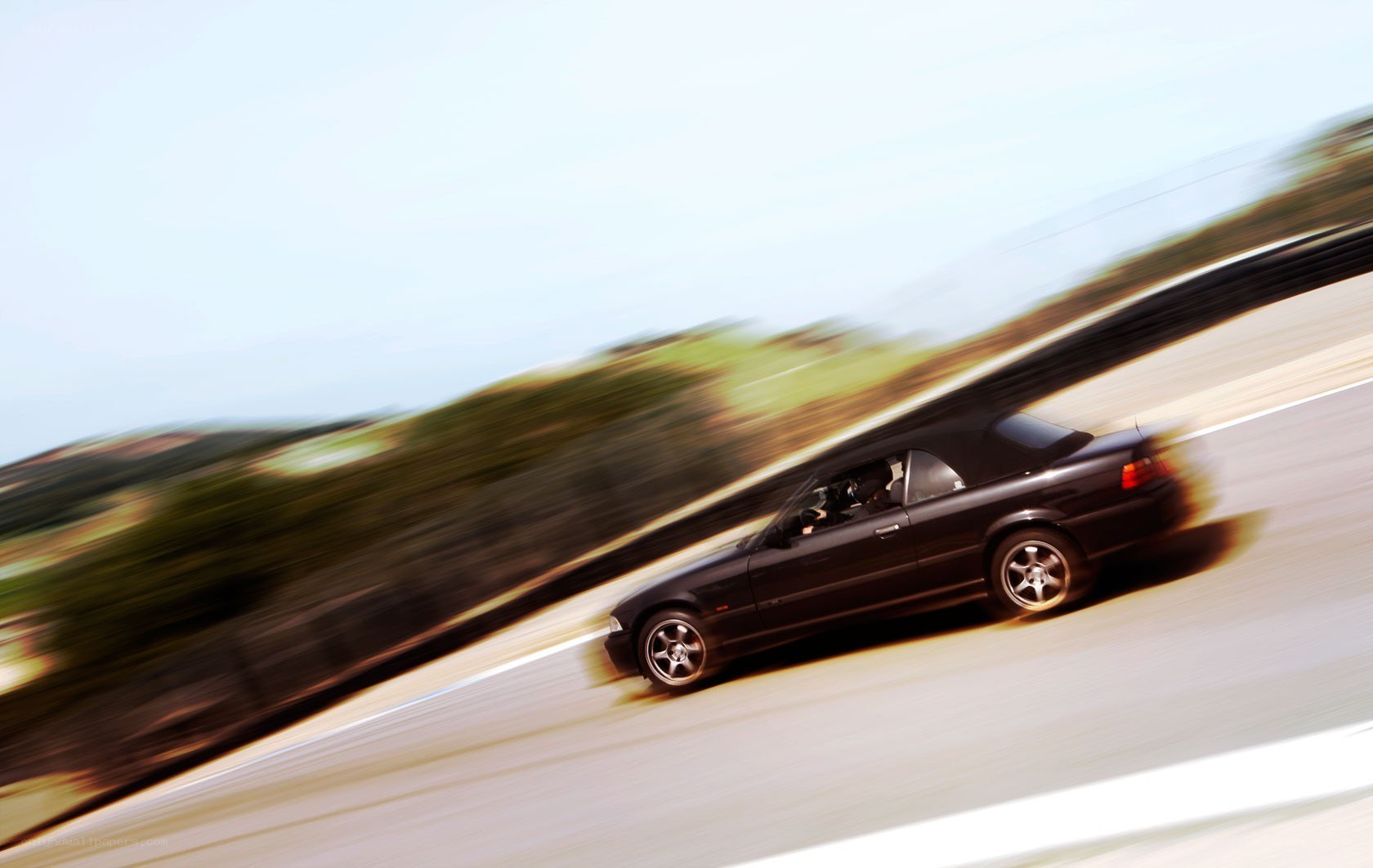 Black convertible speeding on track