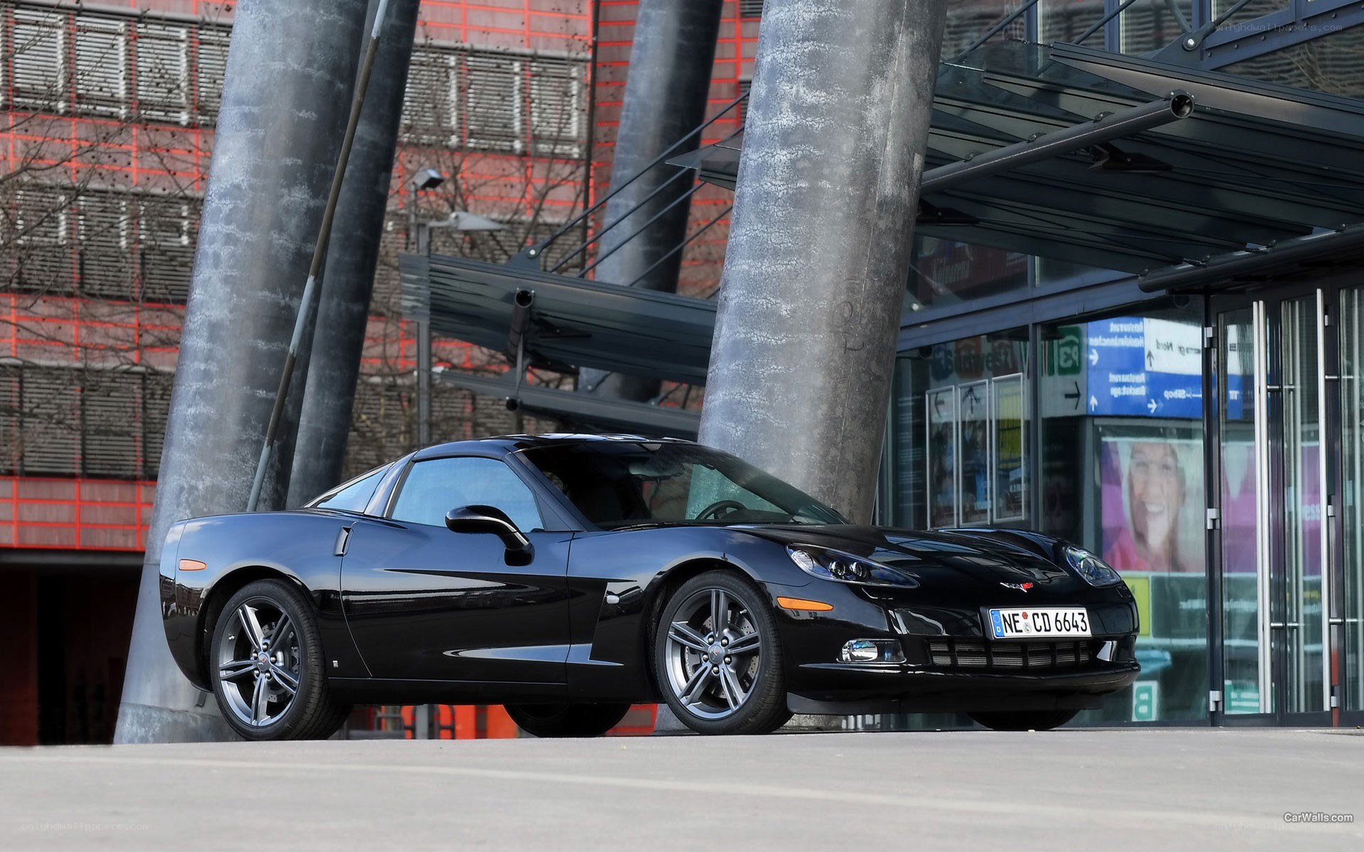 Black Corvette parked outside building