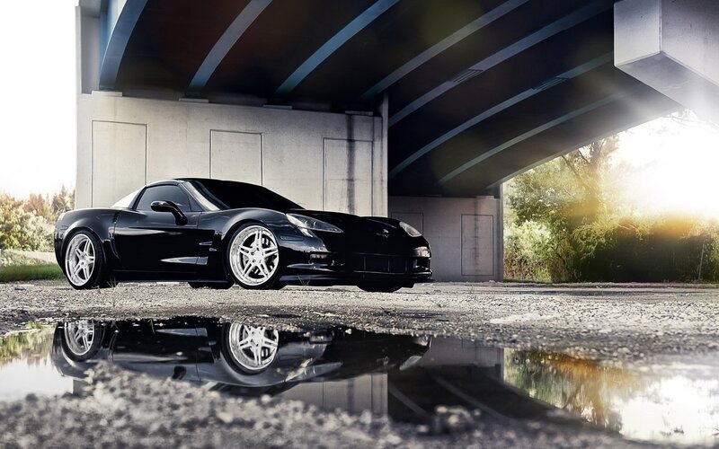Black Corvette under a bridge