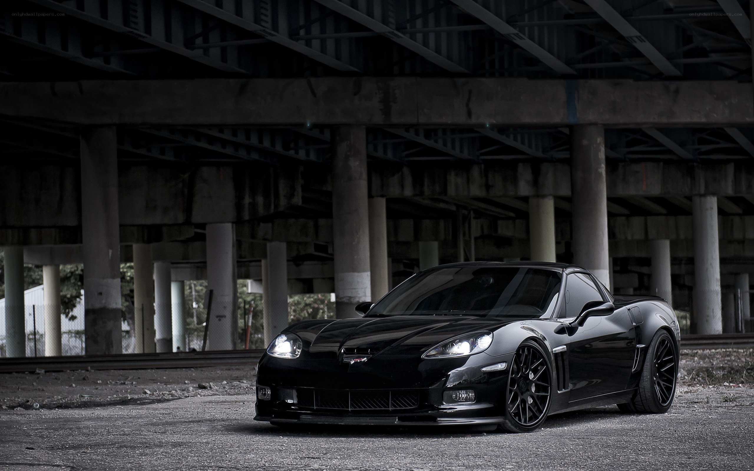 Black Corvette under a bridge