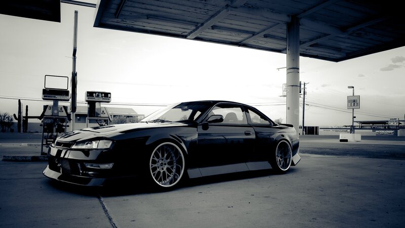 Black coupe at gas station