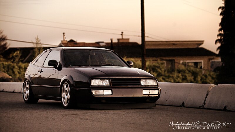 Black Coupe Car — Dramatic, Sunset, Photograph, Concrete Barrier