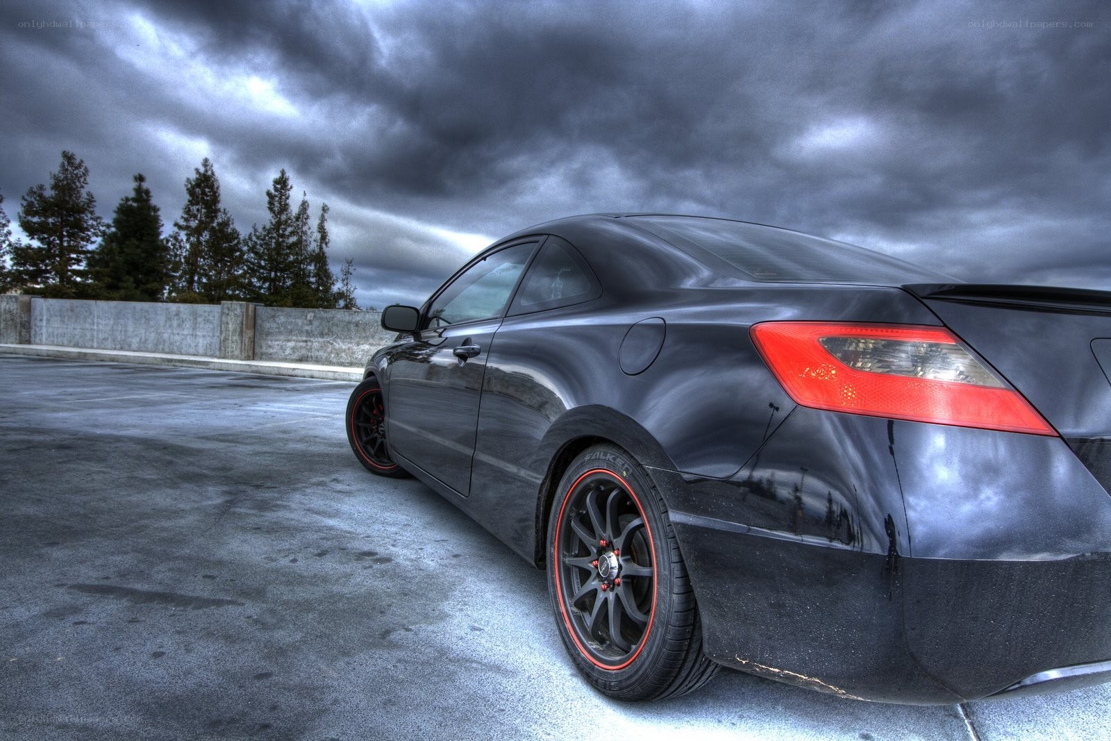Black coupe under stormy sky